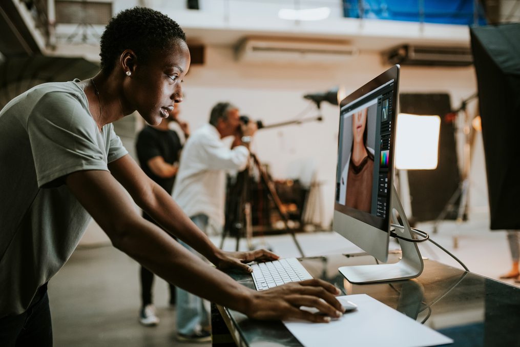 Graphic designer editing a photo at a computer during a professional photo shoot